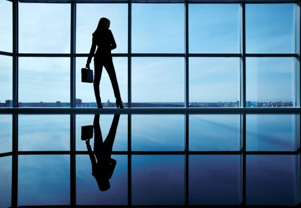 Outline of office worker with briefcase standing by the window